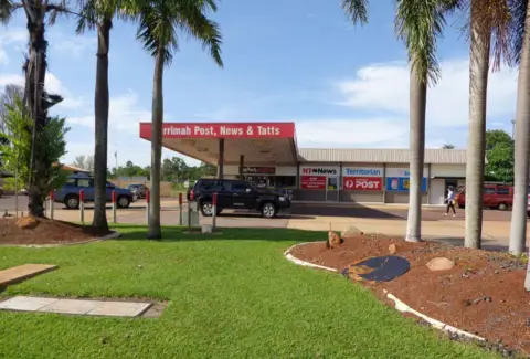 Suburban post office and newsagency with palm trees