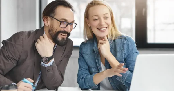 Two colleagues collaborating over a laptop.