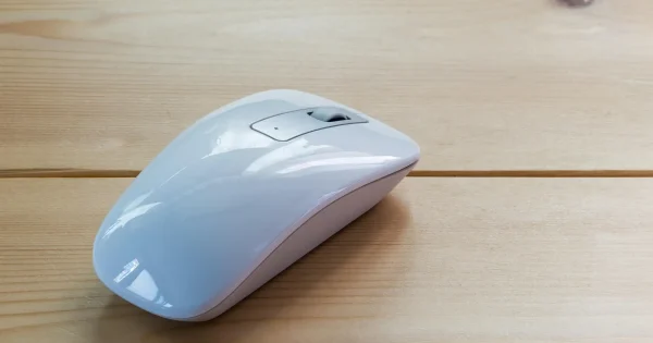 White computer mouse on wooden desk